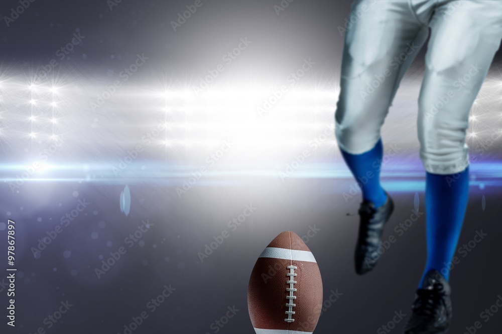 American football player kicking ball