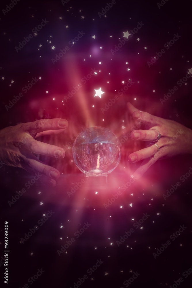 Composite image of serious fortune teller using crystal ball 