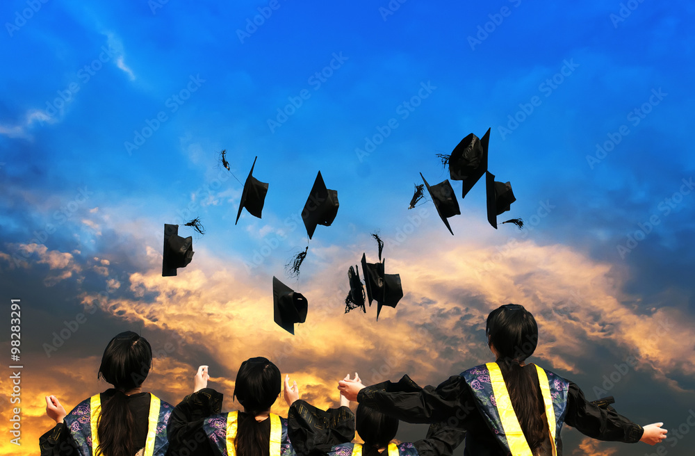 graduates throwing graduation hats in the air.