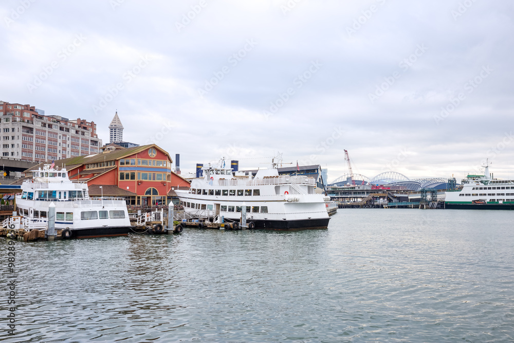 yachts and liner along dock on sea in cloudy sky