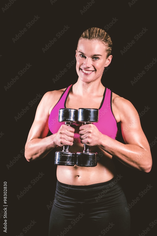 Composite image of muscular woman lifting heavy dumbbells