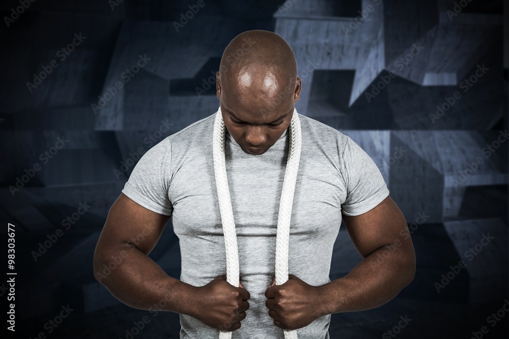 Composite image of fit man with battle rope