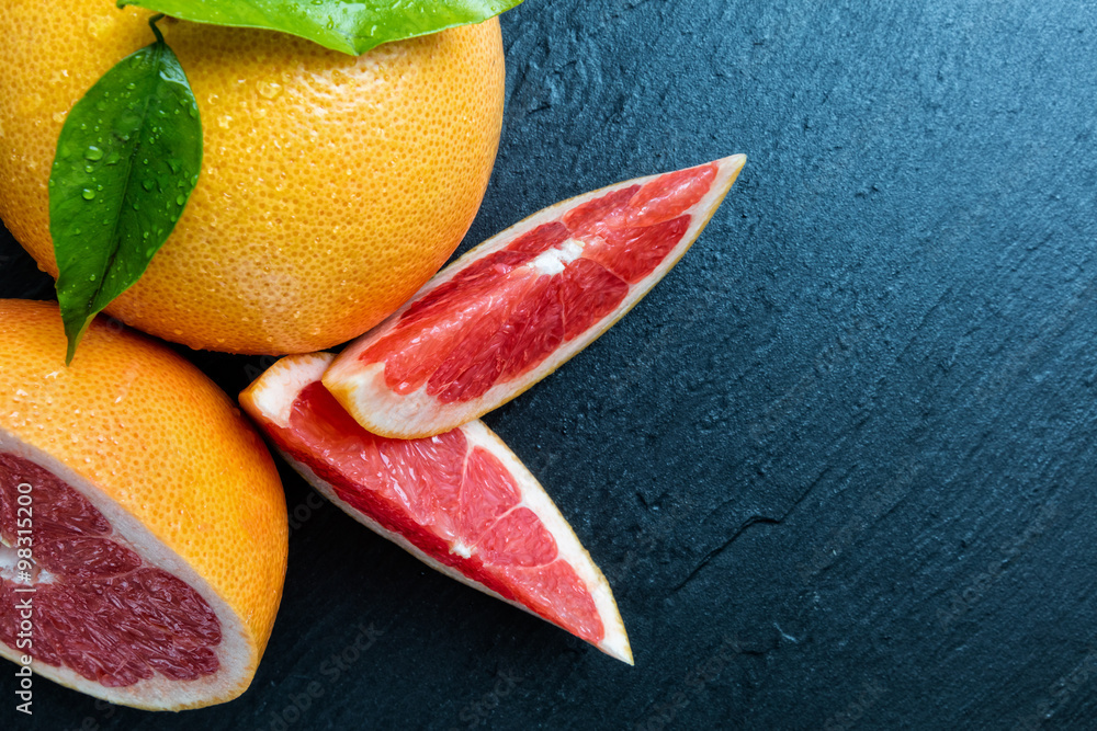 Fresh grapefruit on black stone