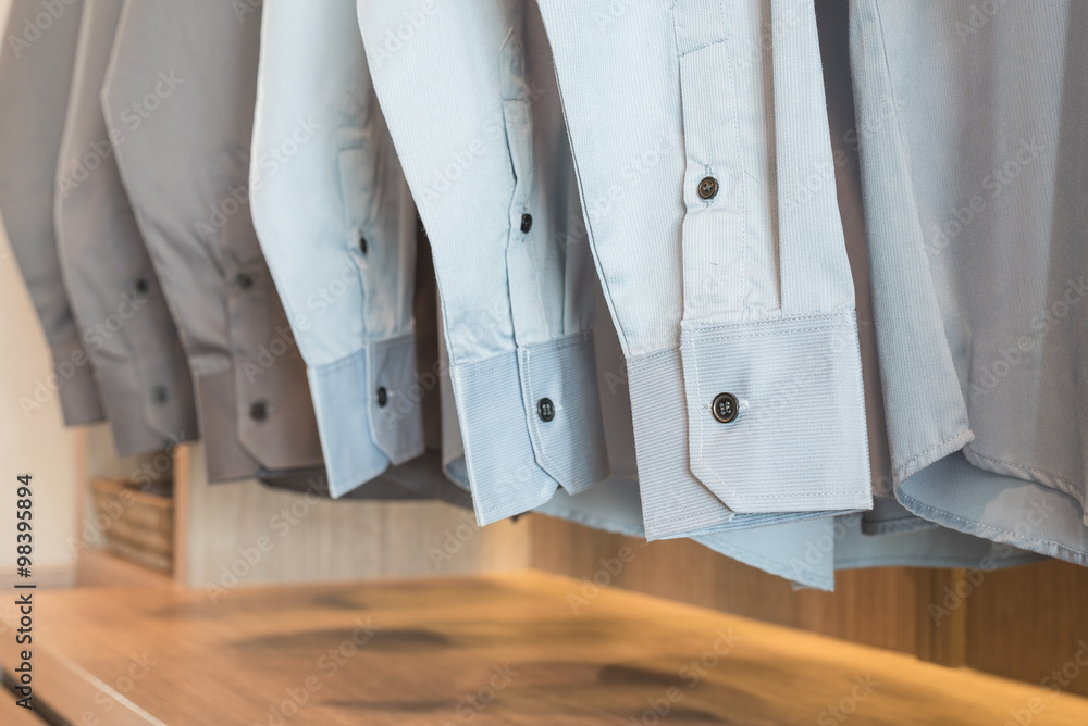 row of shirts hanging on rack with buttons