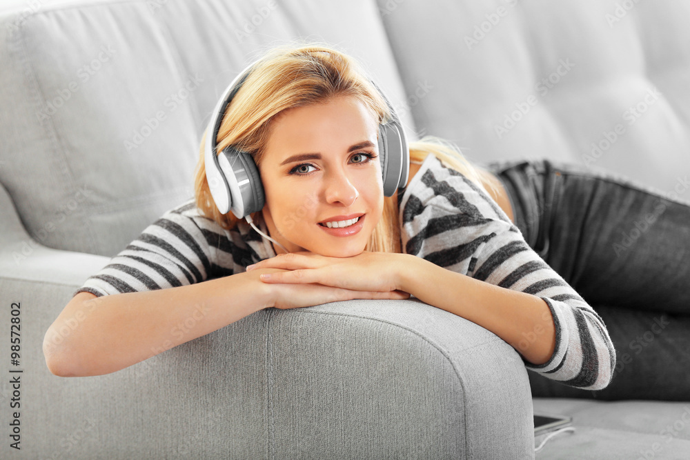 Young woman on a sofa listening to music