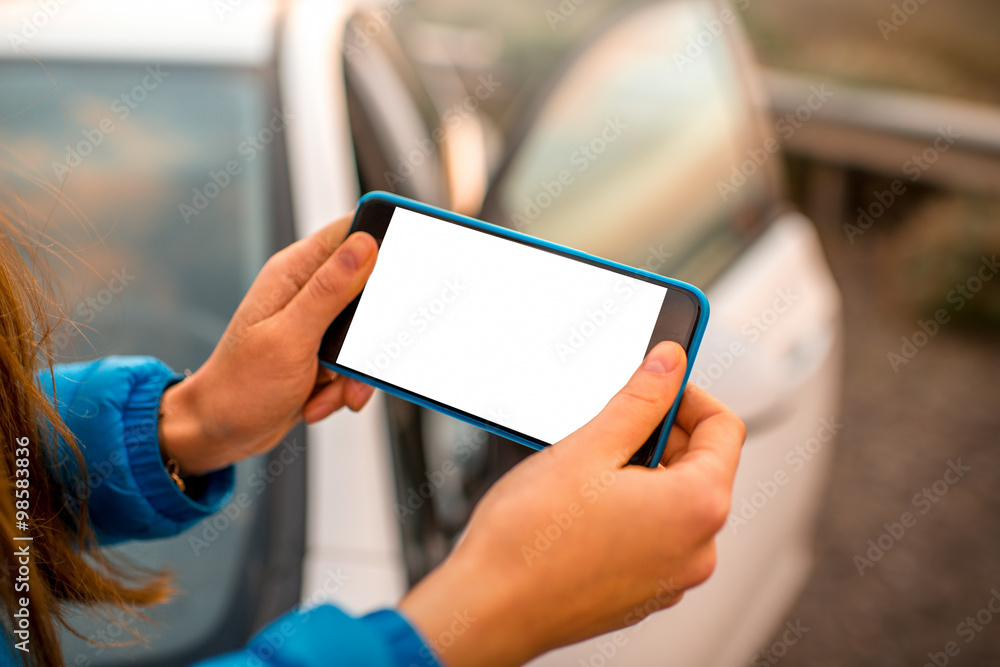 Female hands using smartphone on the road