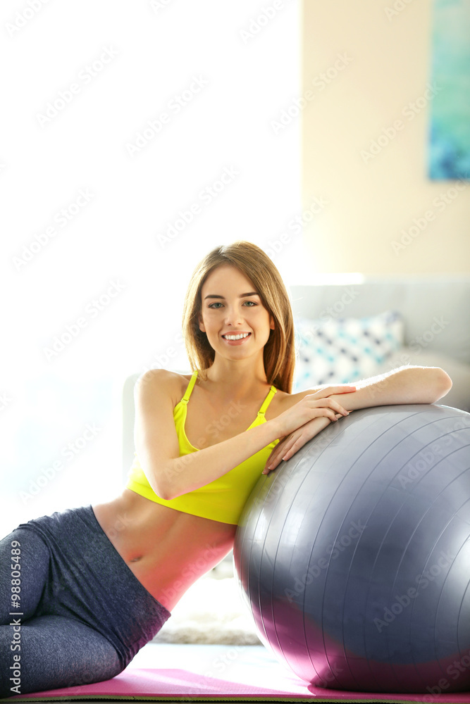 Beautiful young girl with fit ball at home