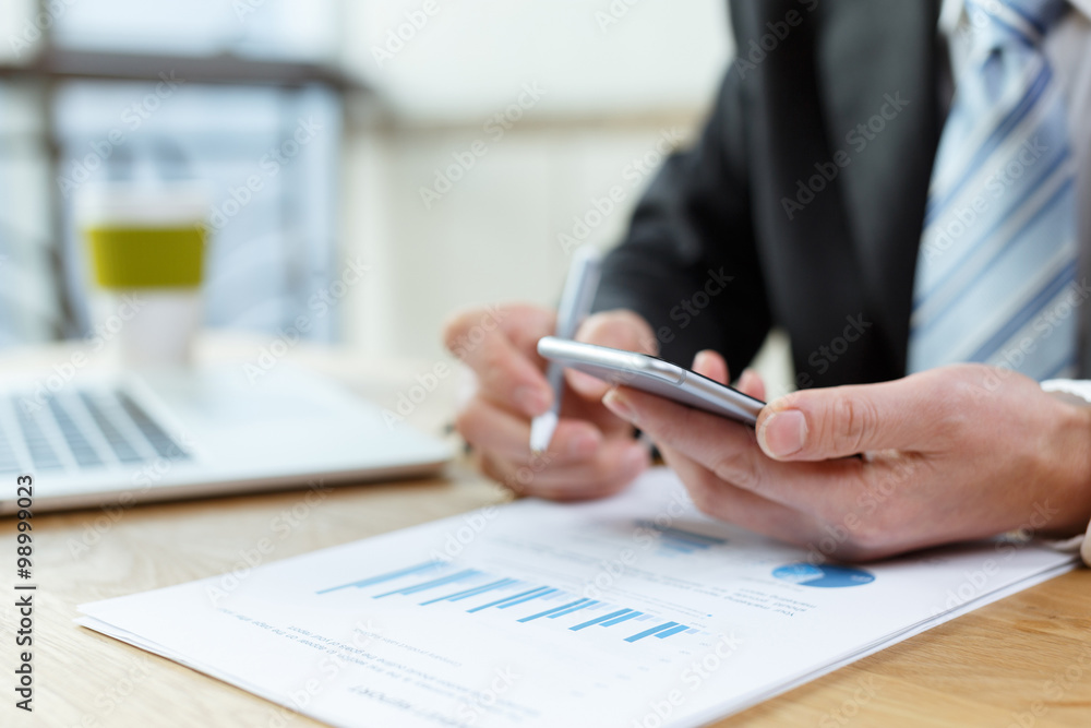 businessman checking financial reports on table