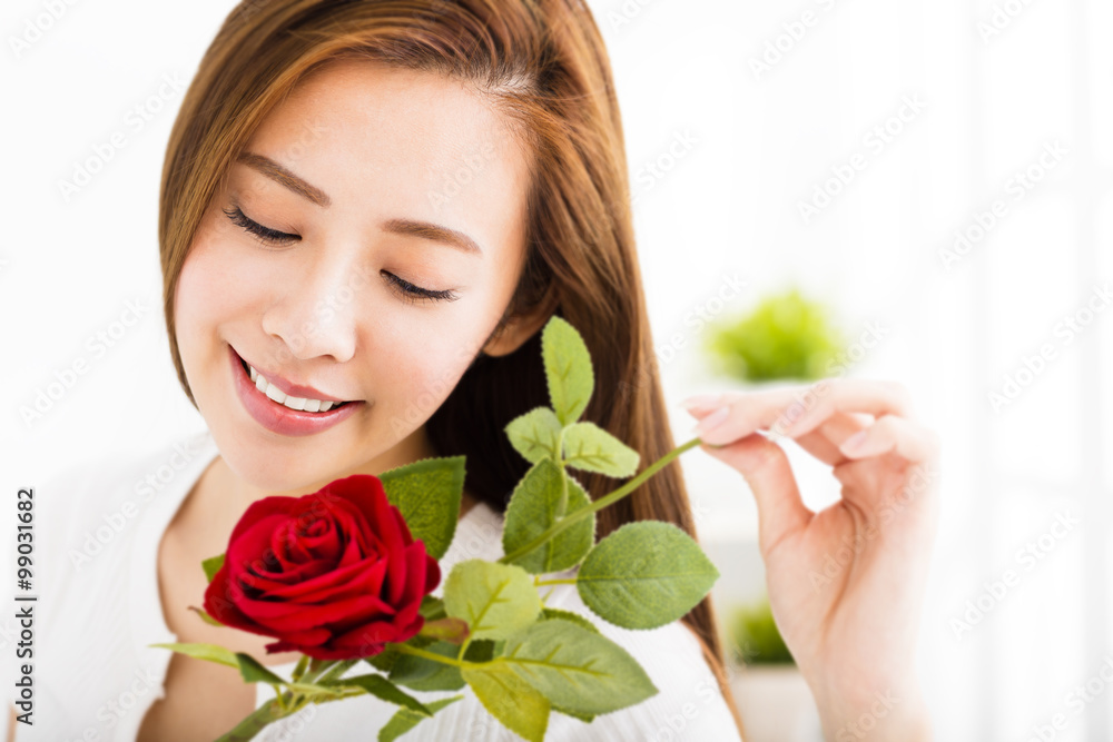  beautiful young woman with red rose in living room