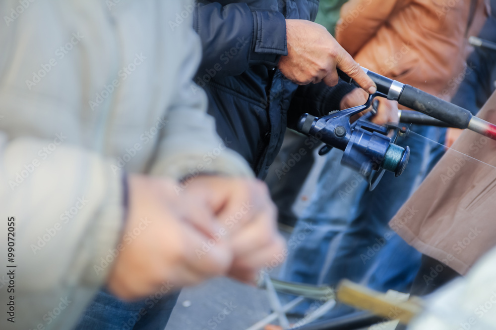 Close up of guy sitting on bridge and fishing