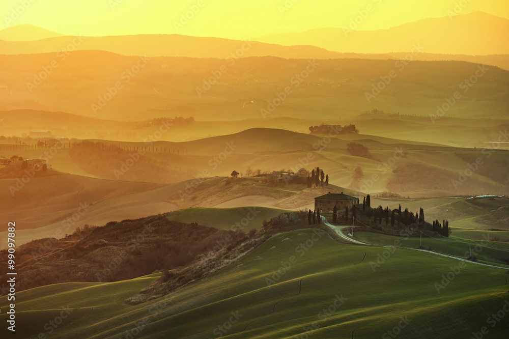 Tuscany spring, rolling hills on misty sunset. Rural landscape.