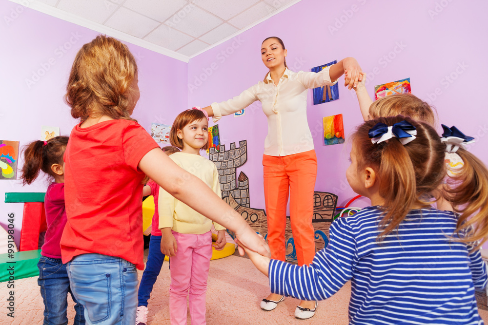 Group of kids play roundelay around girl 