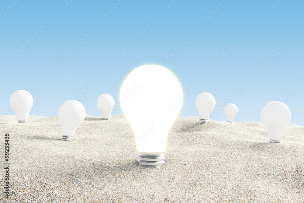 Idea concept with glowing lightbulb in desert