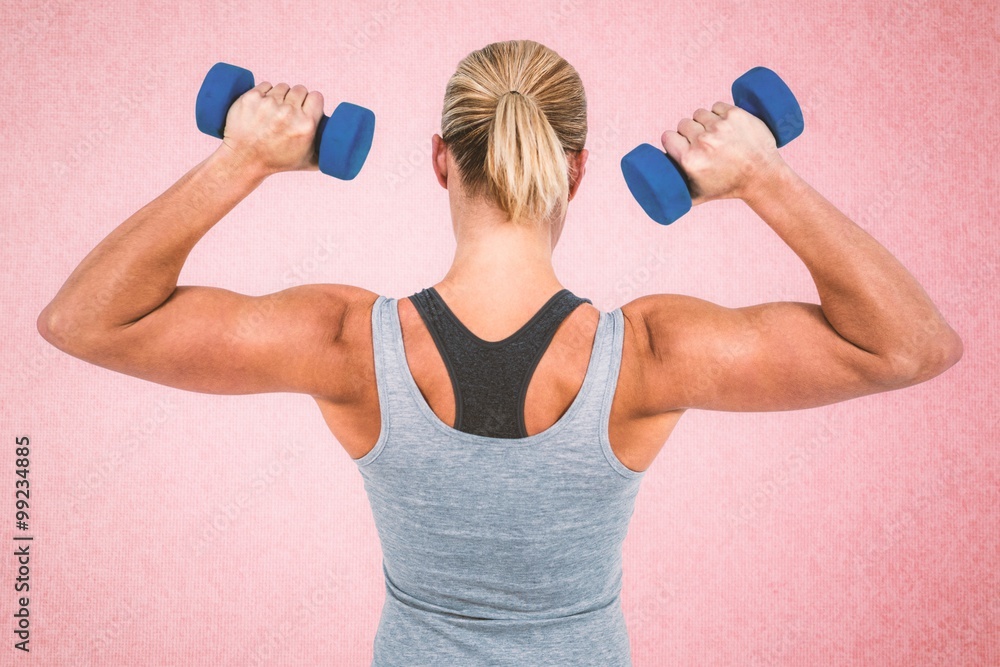 Composite image of  muscular woman working out with dumbbells 