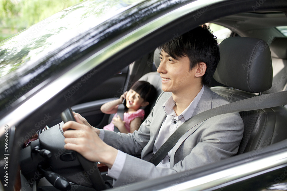 Cheerful father driving with daughter in front seat