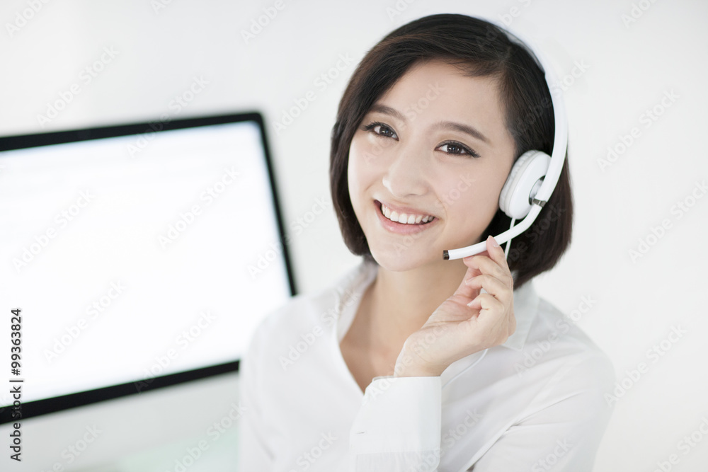 Cheerful businesswoman with headset in office