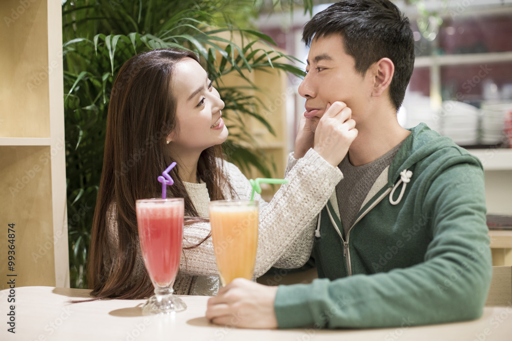 Happy young couple drinking juice