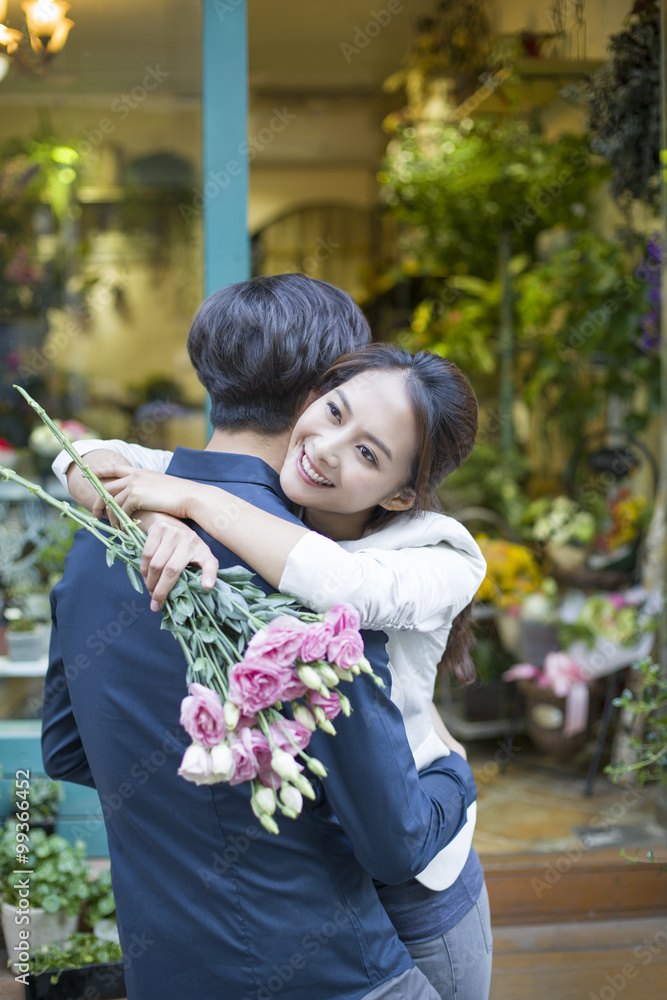 年轻女子用鲜花拥抱男友