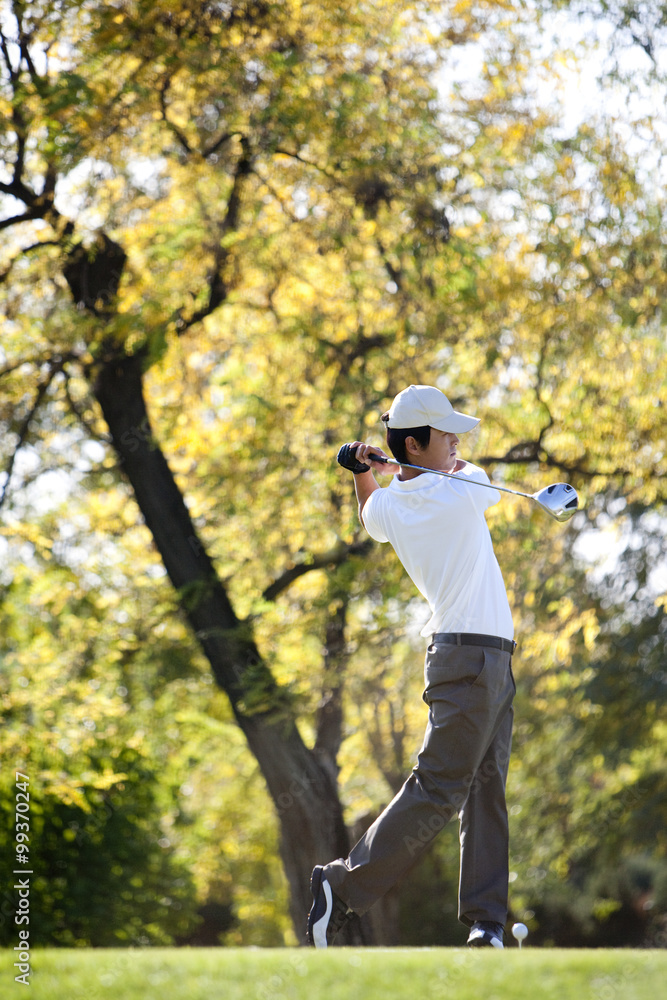 Young Man Taking a Golf Swing