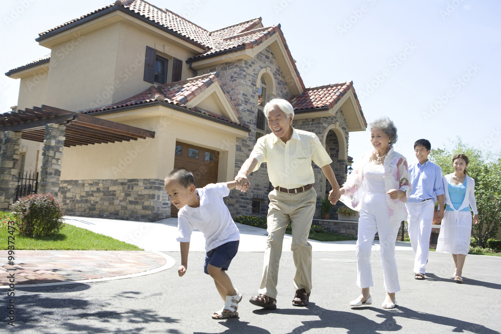 Three generation family walking by a house