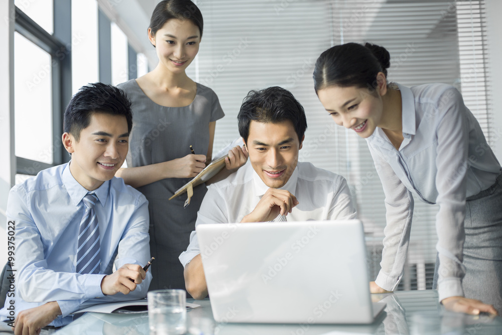 Young business people using laptop in office