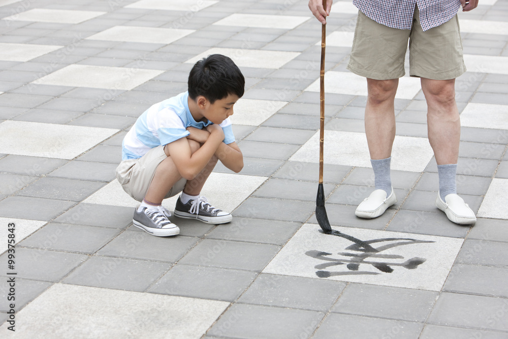 Grandfather teaching grandson calligraphy