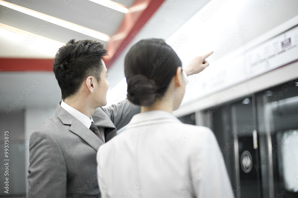 年轻商人在地铁站台上为女商人指路