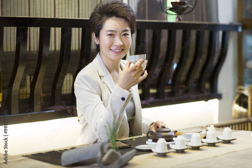 Businesswoman drinking tea in tea room