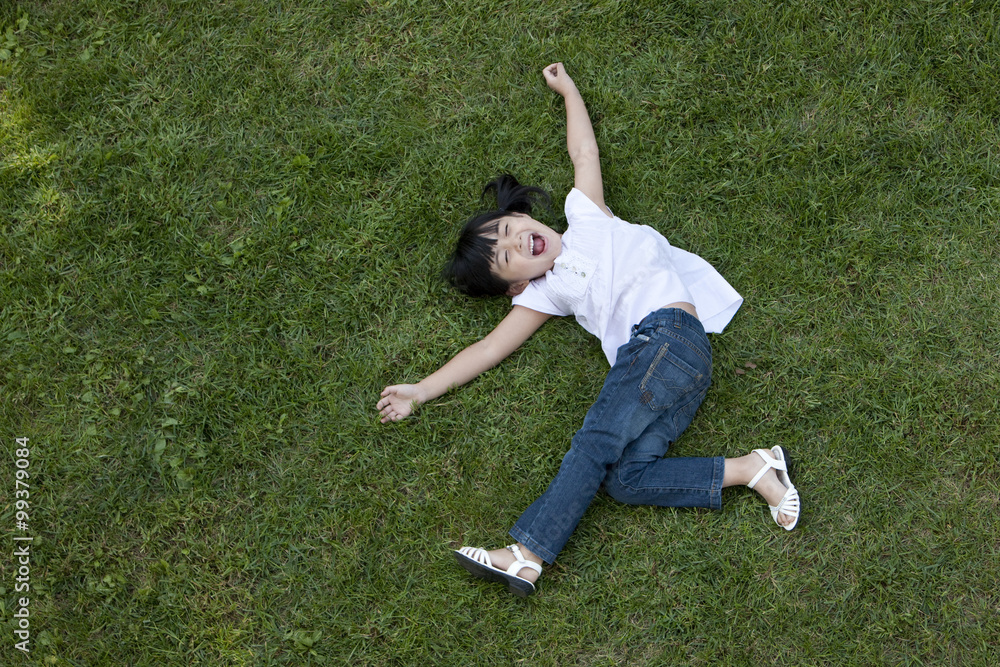 Ecstatic Chinese girl lying on the grass