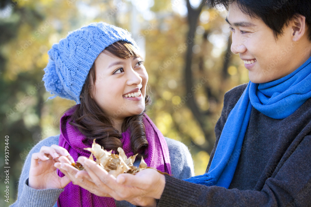 Young Couple in the Park With Maple Leaves