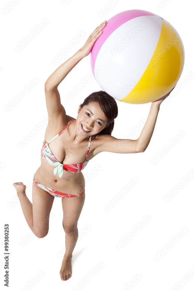 Young woman in bikini holding a ball