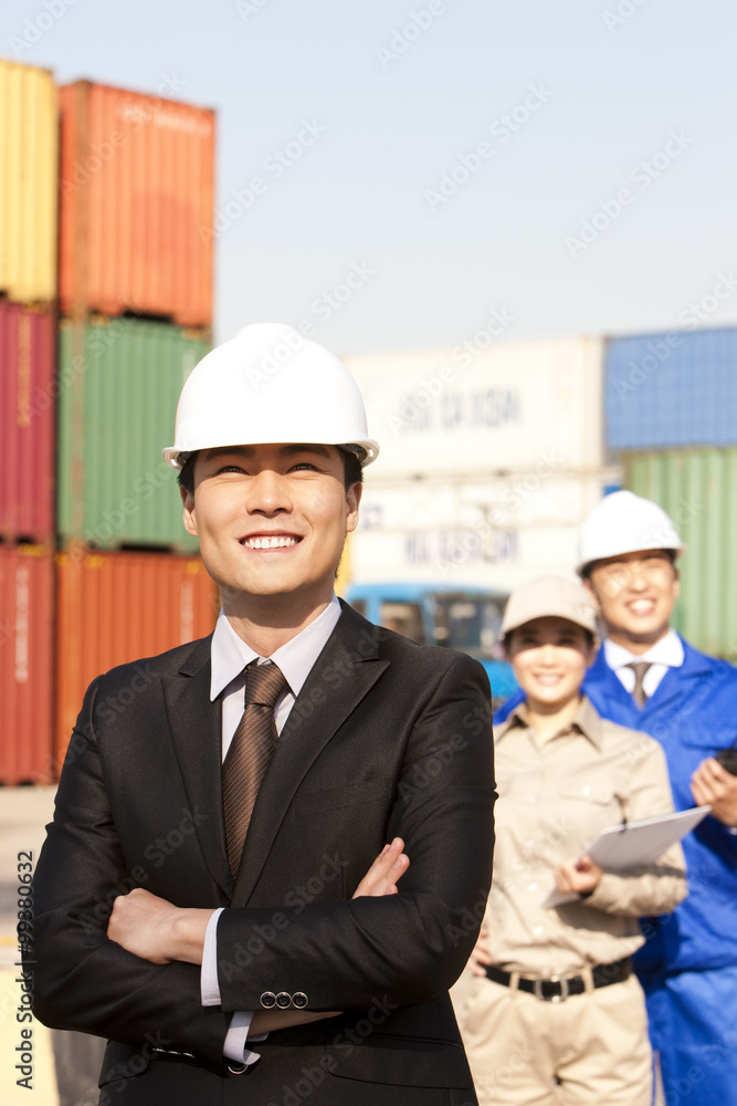 businessman with shipping industry workers in the background