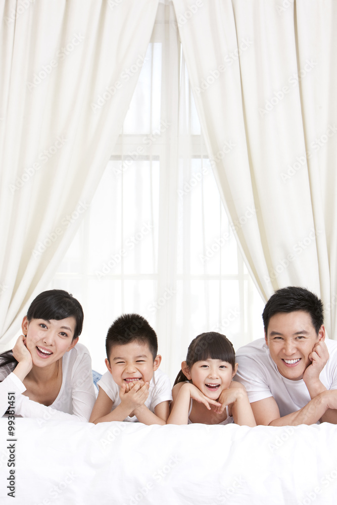 Happy family lying in bed