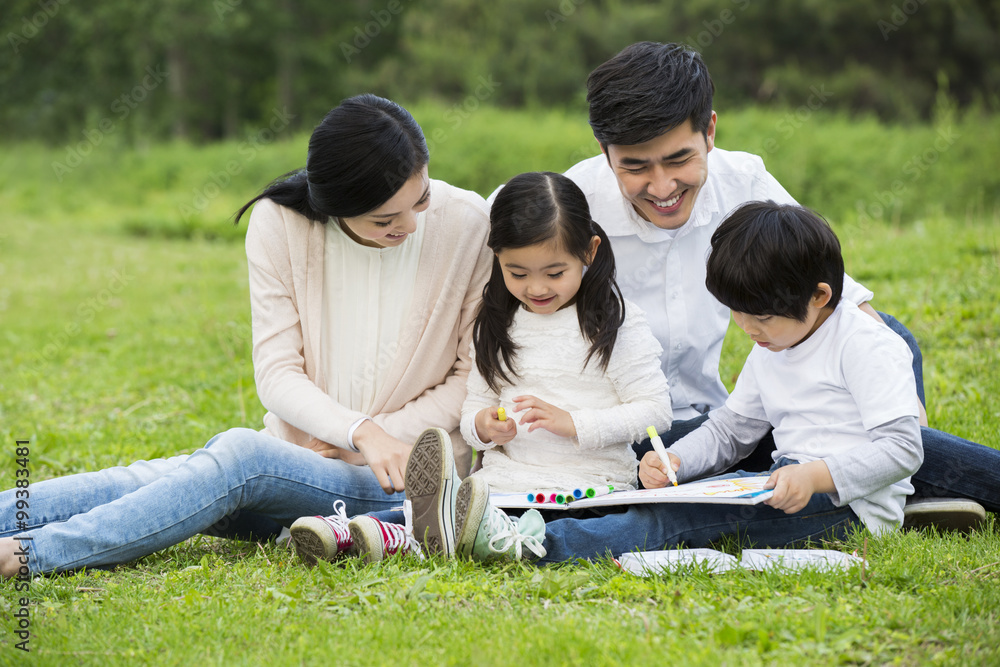 Happy family drawing on the grass