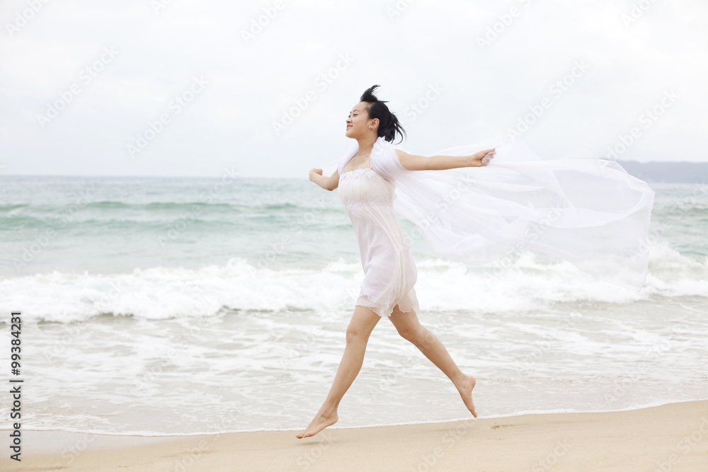 一位年轻女子在海滩上奔跑的肖像