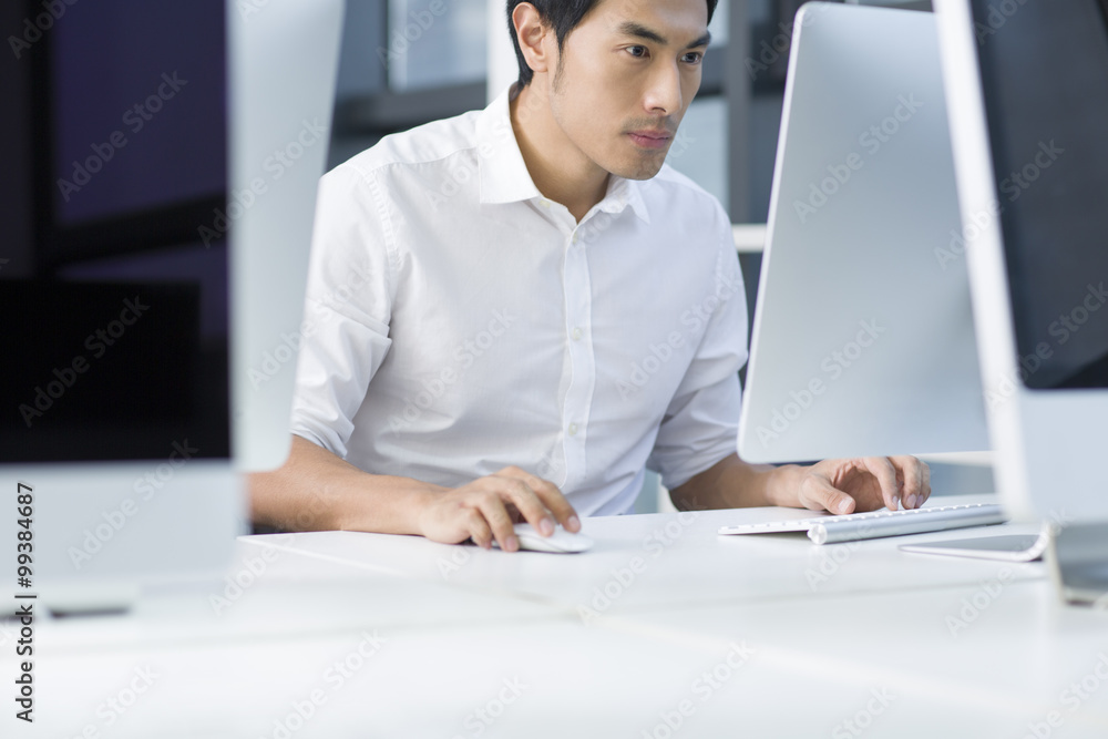 Young businessman using computer in office