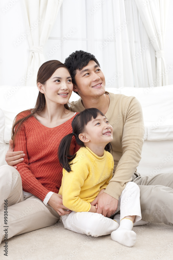 Happy young family sitting on carpet