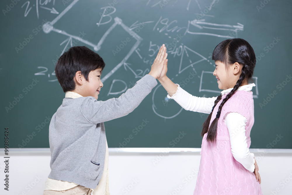 小男孩和小女孩在教室里击掌