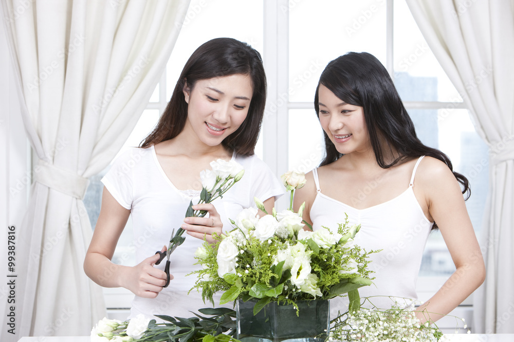 Best female friends arranging flowers together