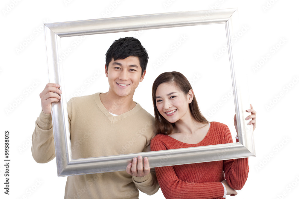 Happy young couple and picture frame