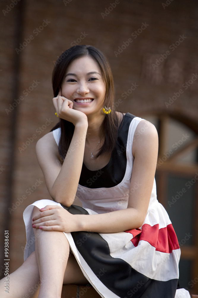 Smiling young woman sitting on ground