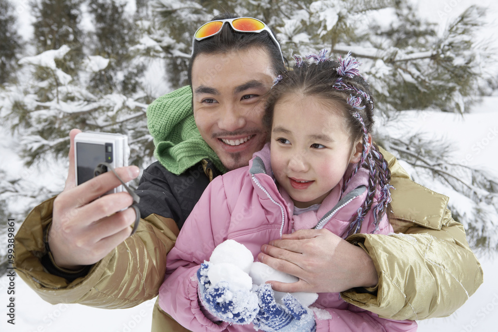 父亲和女儿在滑雪场上自拍