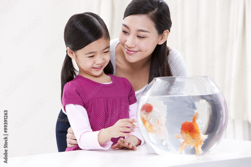 Mother and daughter with goldfish