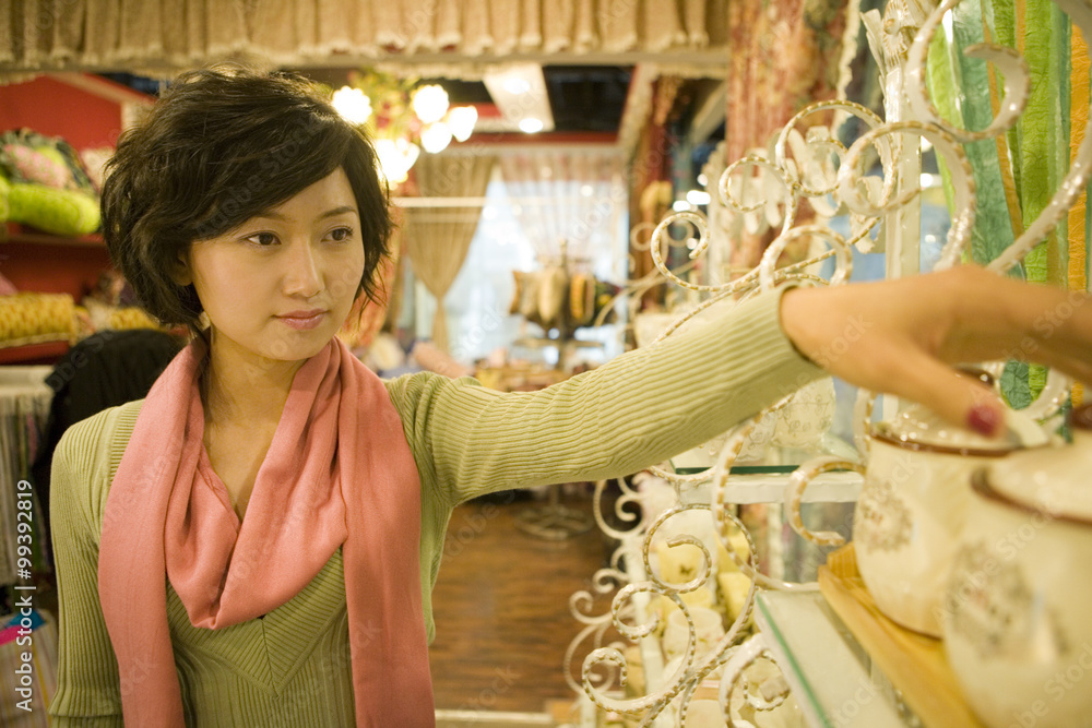 Young Woman Looking At Objects In Shop