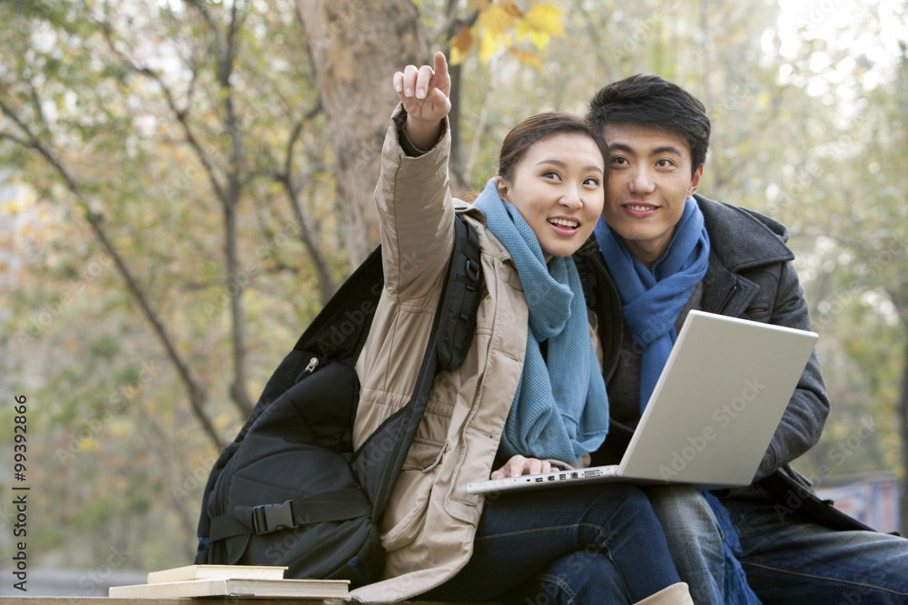 A young man and woman pointing off into the distance