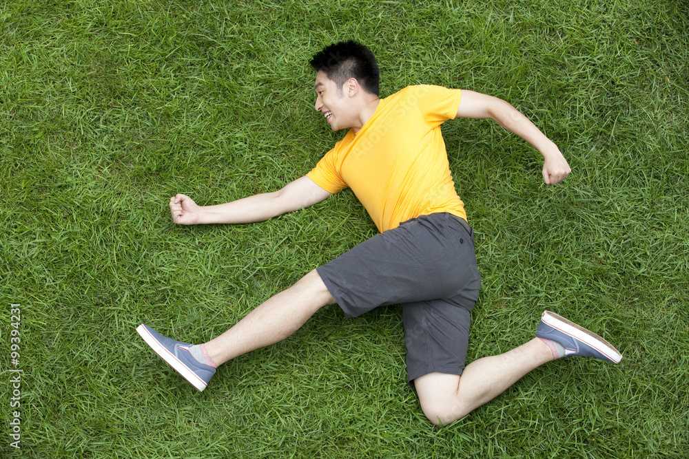 Creative young man imitating running on meadow