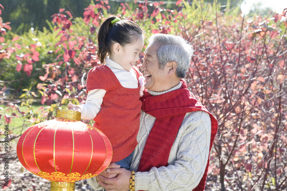 Grandfather and Granddaughter Laughing with Chinese Lantern