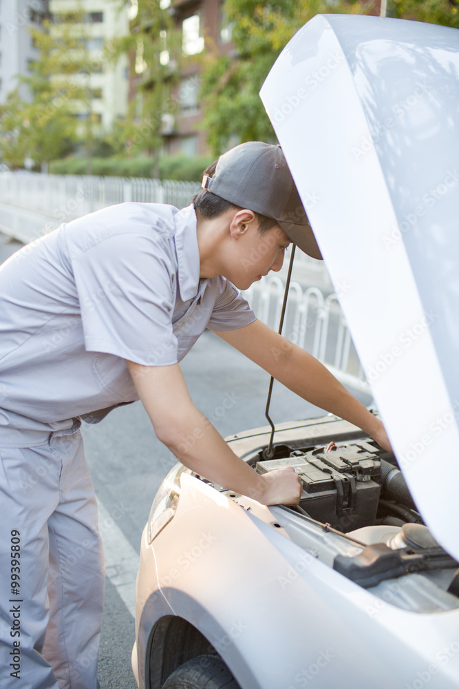 Auto mechanic repairing car