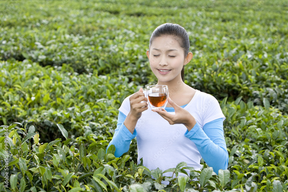 年轻女子在茶园喝茶