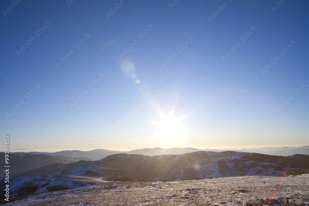 View of the sun setting over a mountain landscape